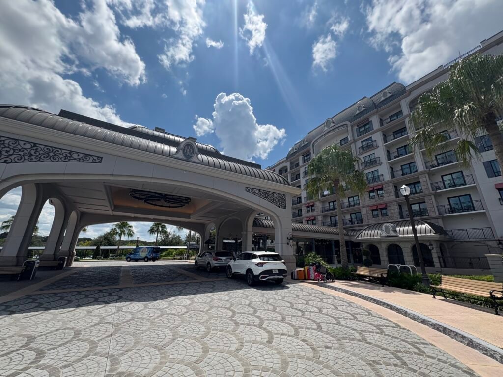 the front entrance to Disney's Riviera resort with cars unloading suitcases